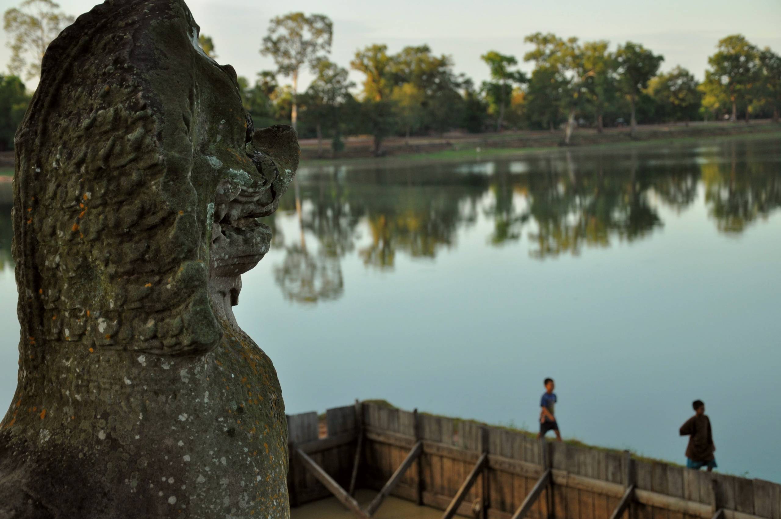 A serene water body surrounded by trees and shrubs, known as Srah Srang in Cambodia
